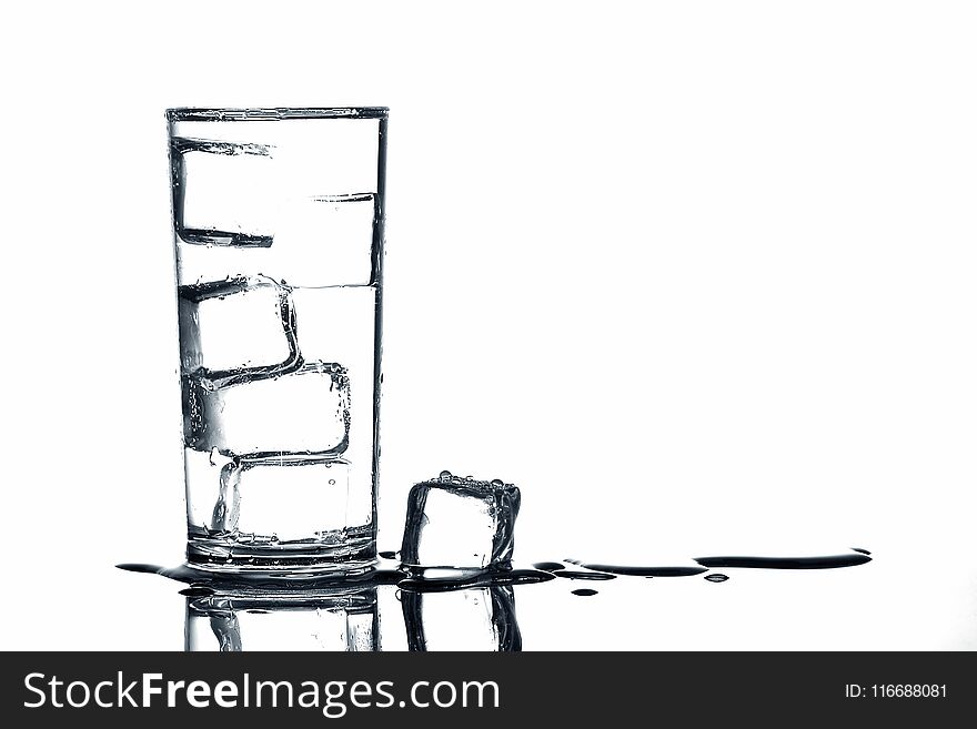 Ice cubes in fresh drinking water in glass on white background