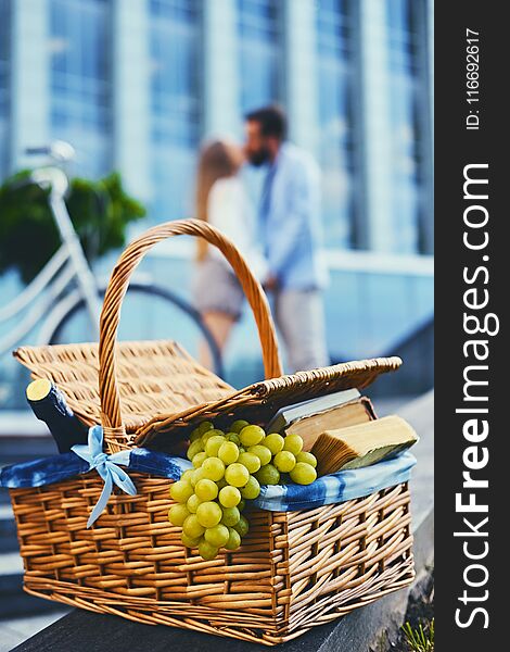A picnic basket full of fruits, bread and wine.