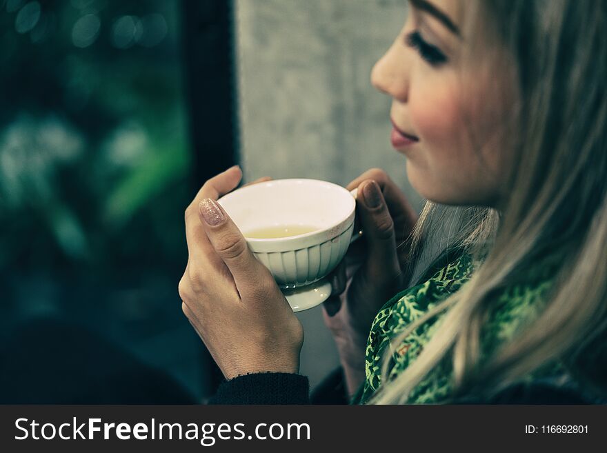 Young woman drinking tea at the coffee shop