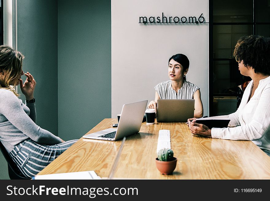 Three People Discussing Inside the Conference Room