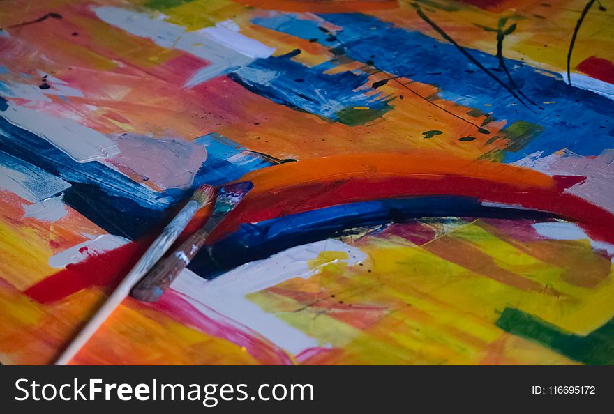 Two Paintbrushes on Multicolored Abstract Painting