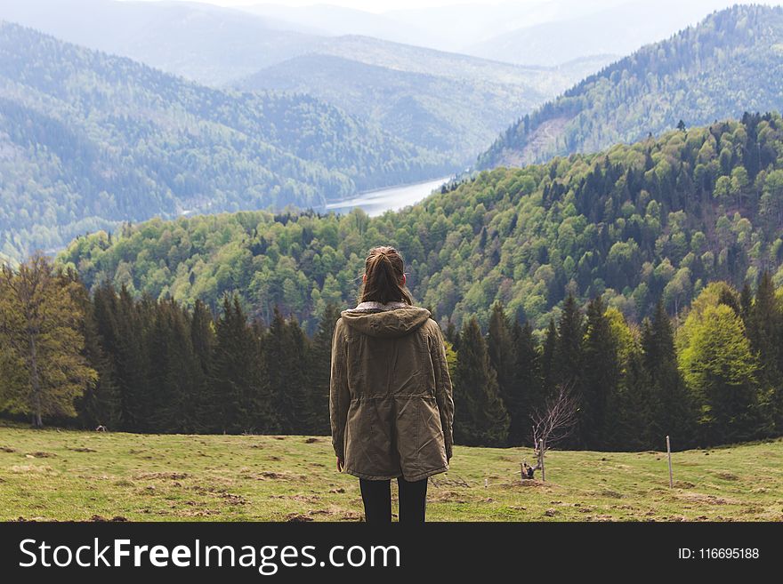 Photo of Woman Wearing Jacket Standing Near Forest Trees