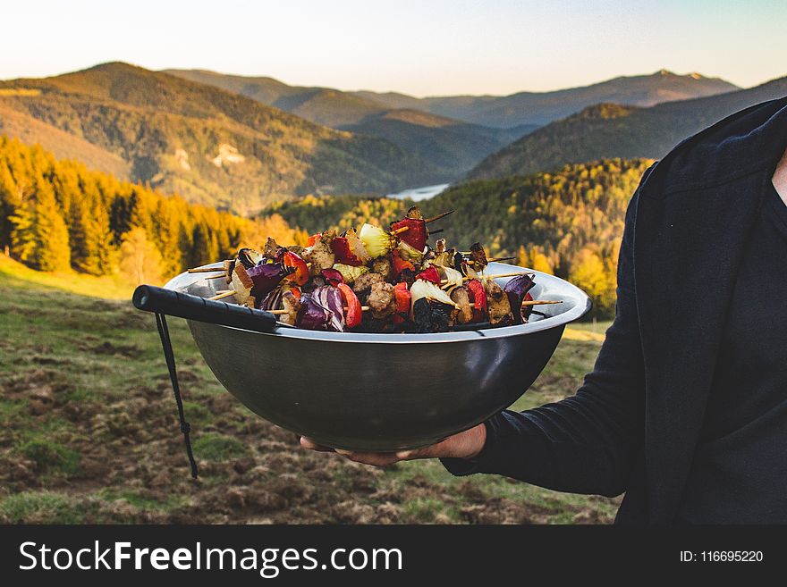 Person Holding a Bowl Full of Barbecue
