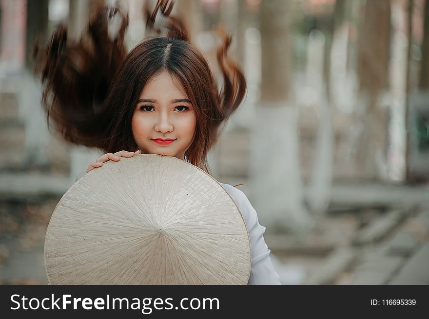 Selective Photography Of Woman Holding Conical Hat