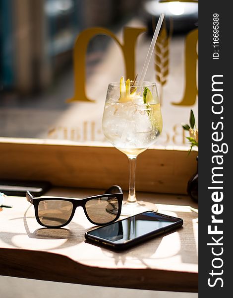 Wine Glass Beside Android Smartphone and Sunglasses