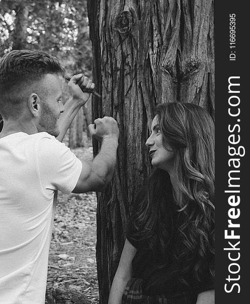 Monochrome Photography of Man and Woman Near Tree