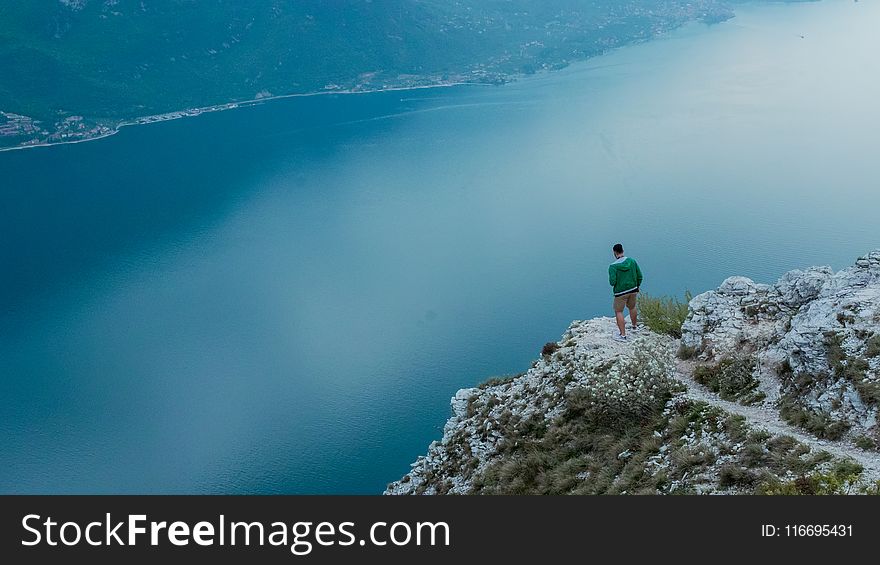 Photo of Man Standing on Cliff