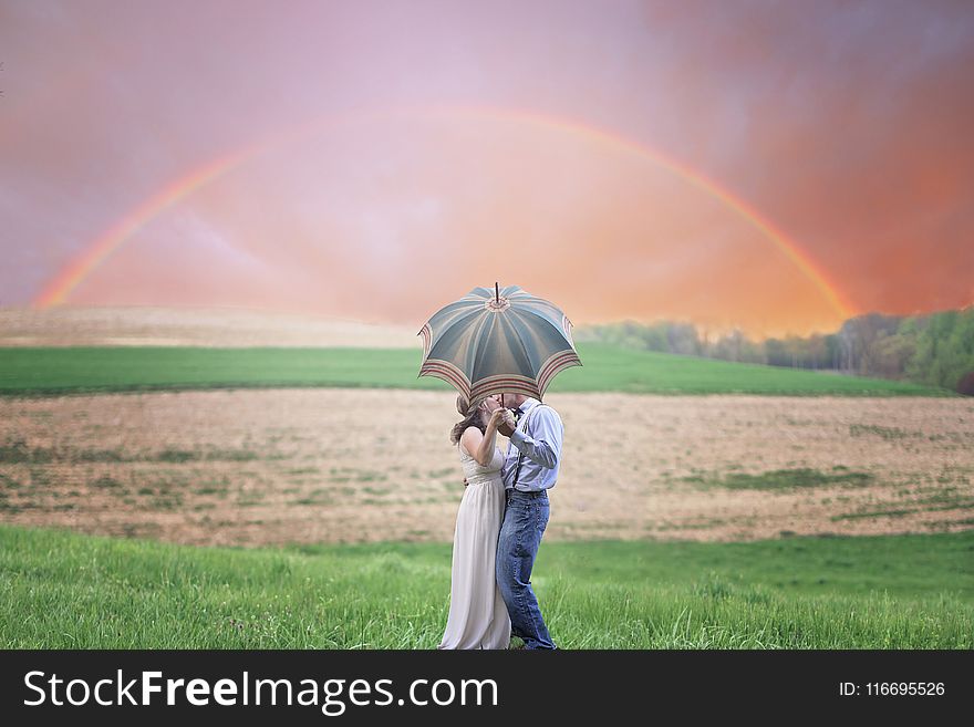 Photo Of Couple Holding Umbrella While Kissing