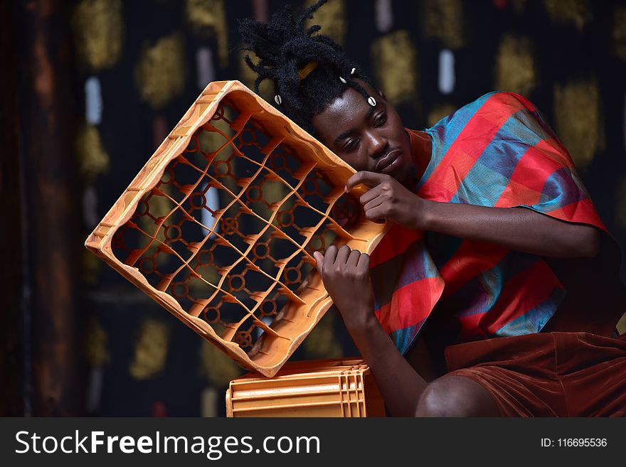 Photography of a Guy Leaning on Plastic Bottle Crate