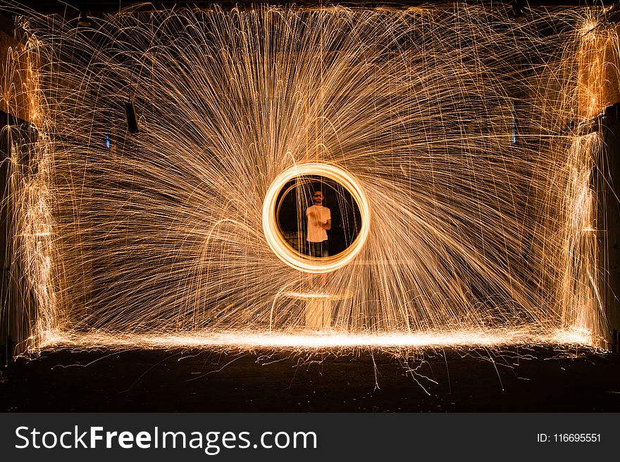 Yellow Sparks in Front of Person in White Top