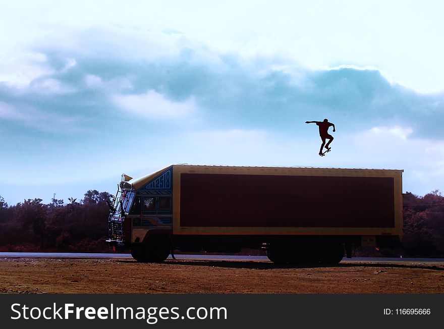 Brown Truck With Man With Skateboard on Top