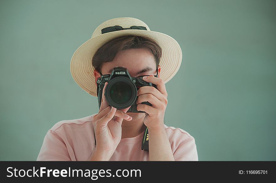 Man In Pink Shirt Holding Dslr Camera