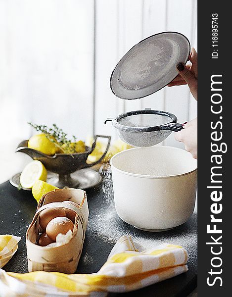 White Plastic Container Beside Basket Of Brown Eggs