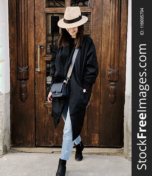 Photo Of Woman Wearing Black Coat And Faded Blue Jeans