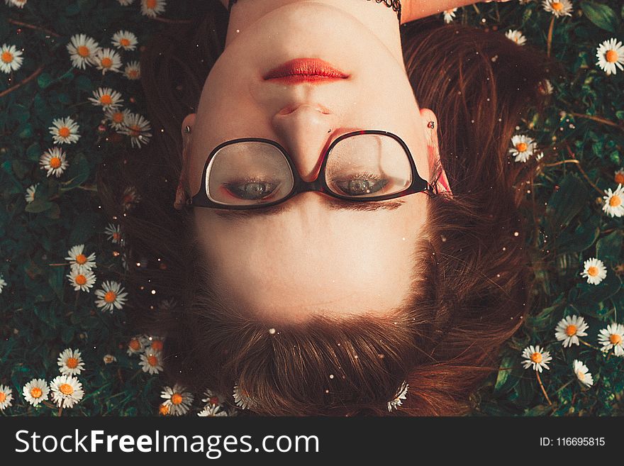 Woman Wearing Eyeglasses Lying On Grass