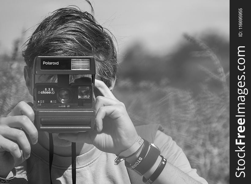 Photo of Person Holding Polaroid Camera