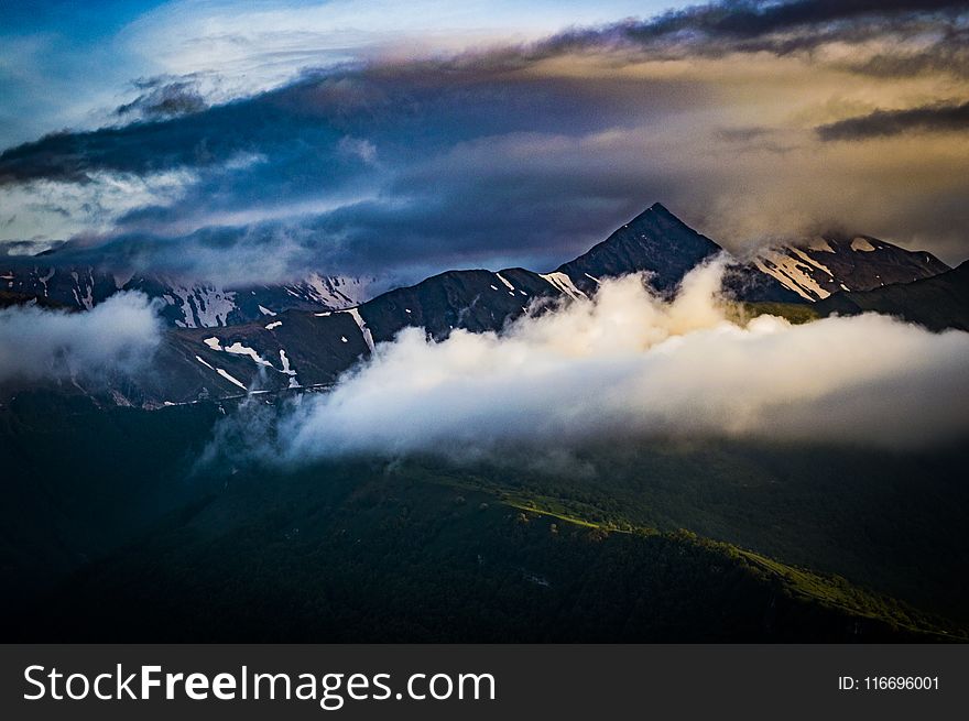 Cumulus Clouds Over Mountain Peak