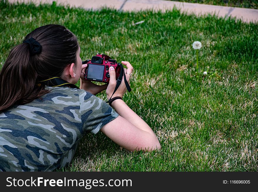 Woman in Camouflage T-shirt Holding Dslr Camera