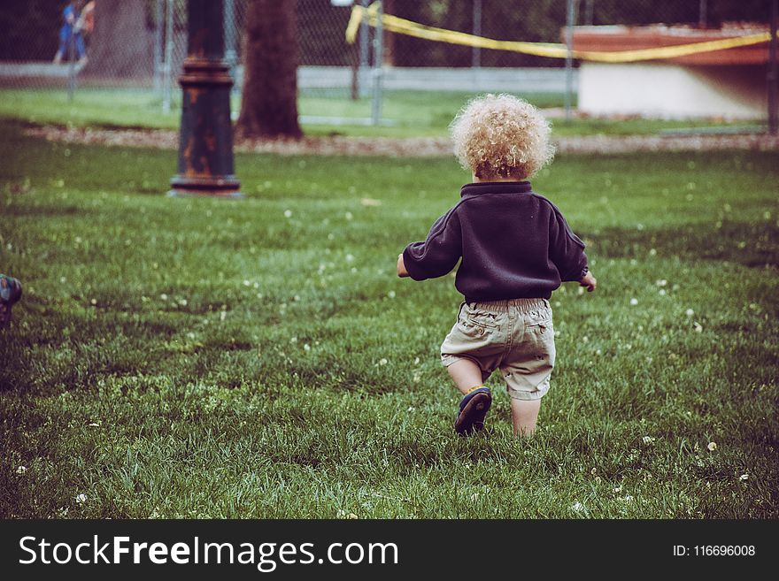 Boy Wearing Brown Shorts Standing On Green Grass