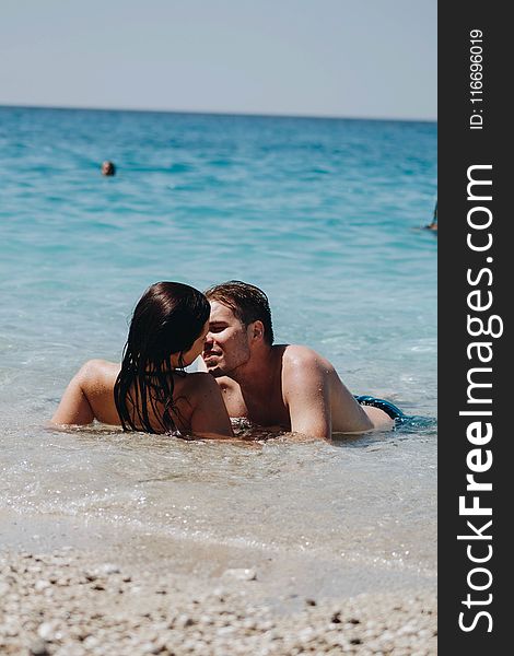 Photo of Man Kissing Woman on Seashore