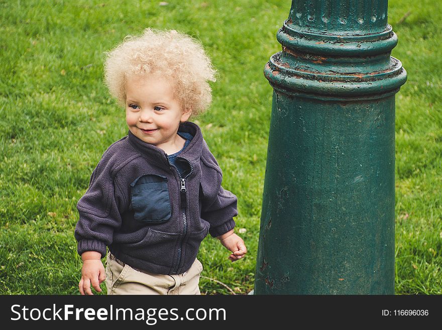 Toddler Wearing Jacket Beside The Light Post