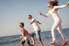 Happy Family Running On The Beach At The Day Time. Stock Photo Happy Family Running On The Beach At The Day Time. Stock Photo