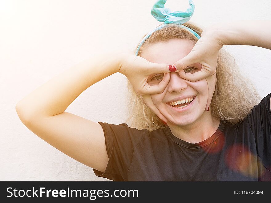 Girl makes faces of the pilot on the background of the gray wall. Girl makes faces of the pilot on the background of the gray wall