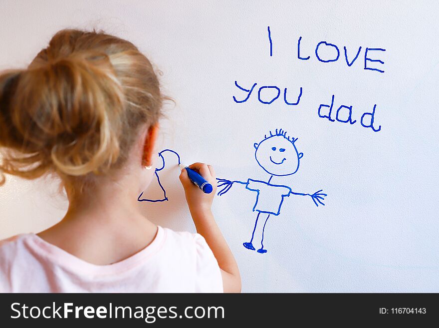 Little girl draws family with marker on a white board. Happy fathers day card.