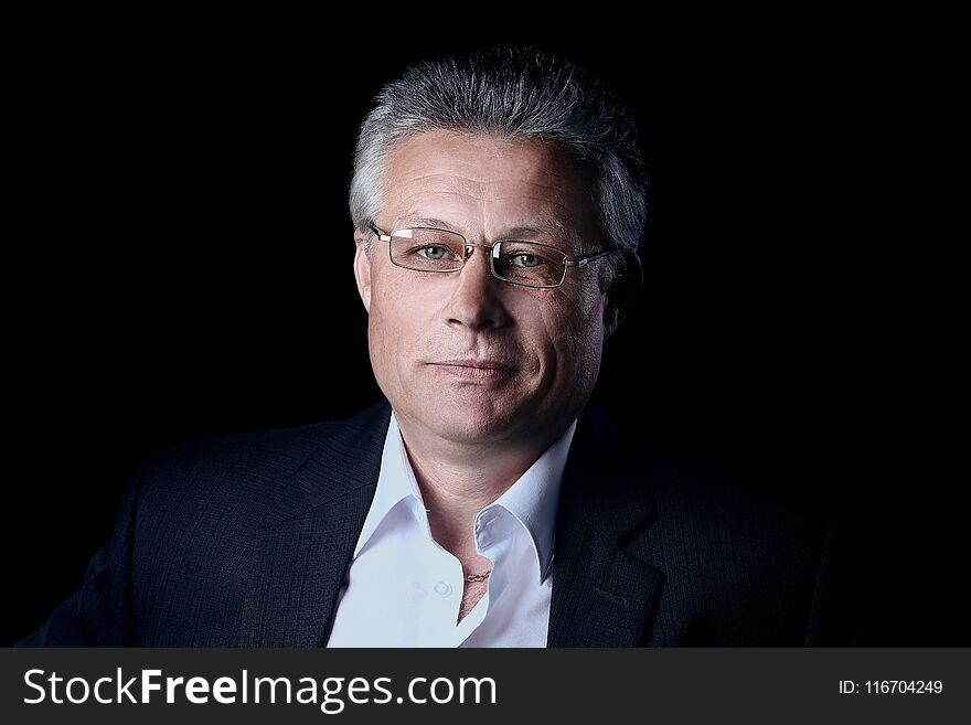 Gray-haired business man smiling isolated on black background.