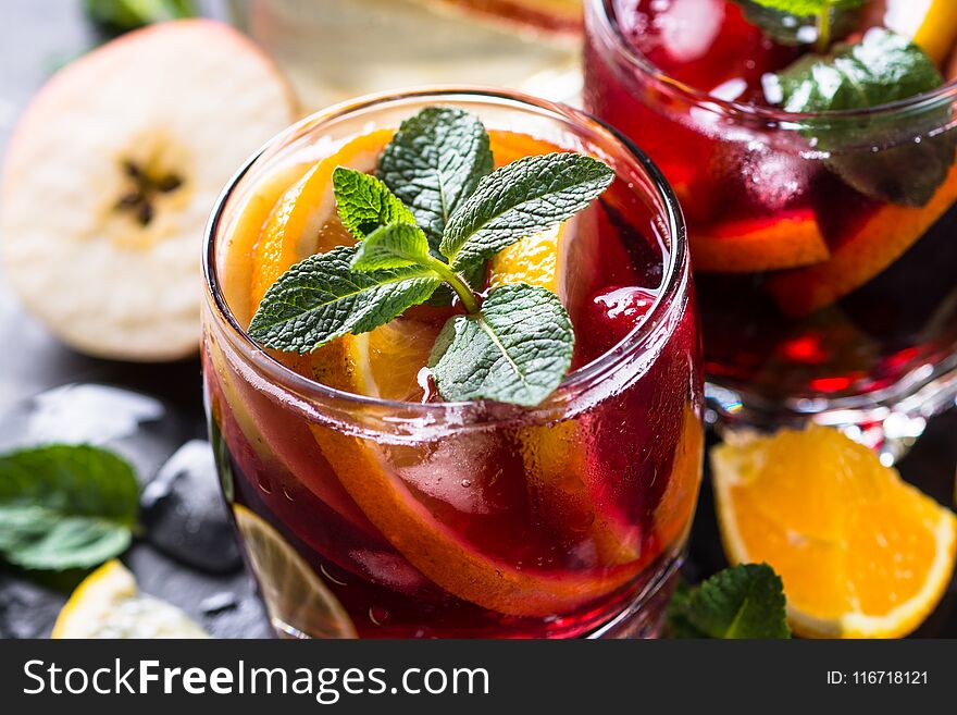 Sangria with fruit, ice and mint in glass.