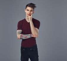 Handsome Fashionable Young Guy With Stylish Hair And Tattoo On His Arm Posing In A Studio. Stock Image