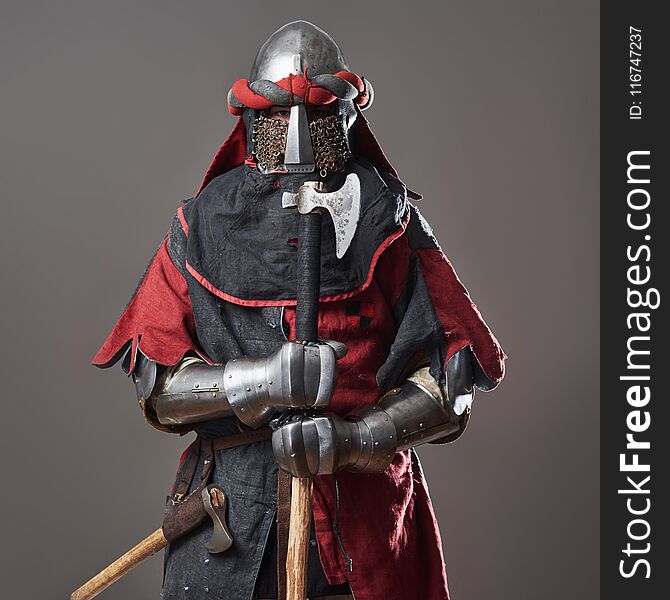 Medieval Knight On Grey Background. Portrait Of Brutal Dirty Face Warrior With Chain Mail Armour Red And Black Clothes