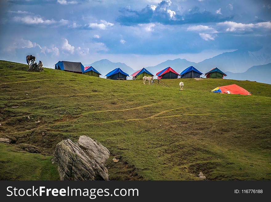 Photographed of Lined Tents on Green Grass Hills
