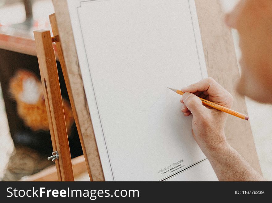 Person Holding Pencil On White Canvas