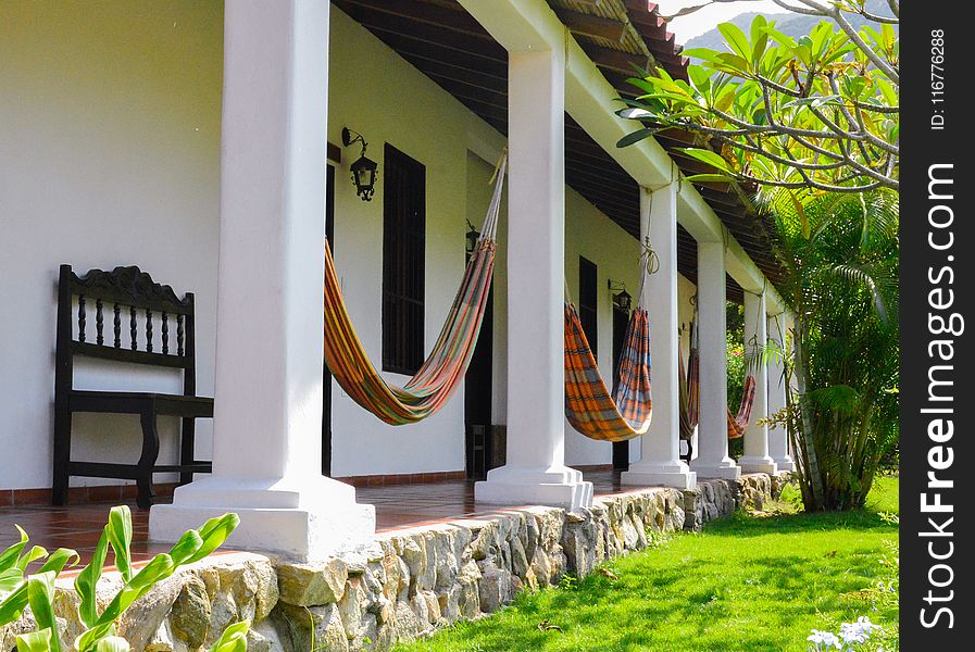 Several Orange Hammocks Hanged On White Concrete Posts