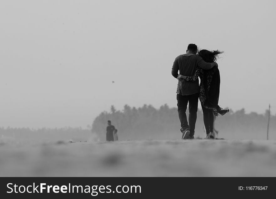 Grayscale Photography of Couple Walking on Ground
