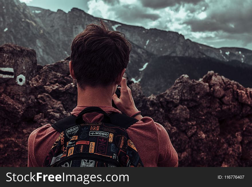 Man Taking Photos Of Mountains