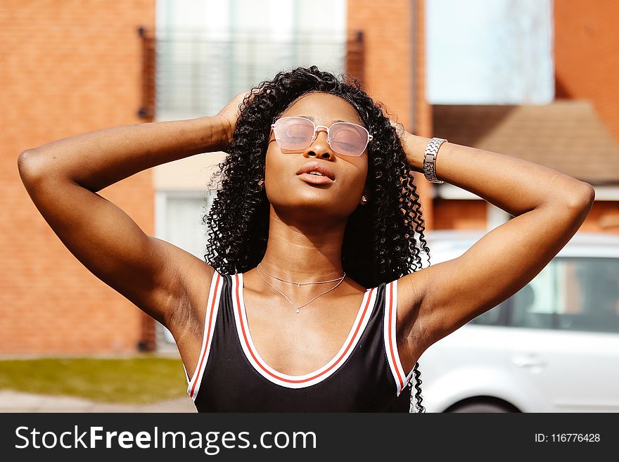 Photography Of Woman In Black Tank Top Holding Her Hair