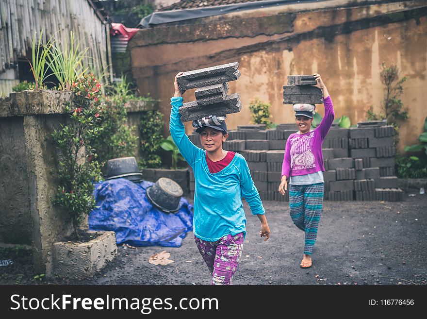 Photography of Women Carrying Cinder Blocks