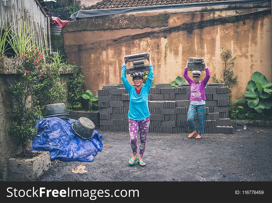 Photography of People Carrying Cinder Blocks