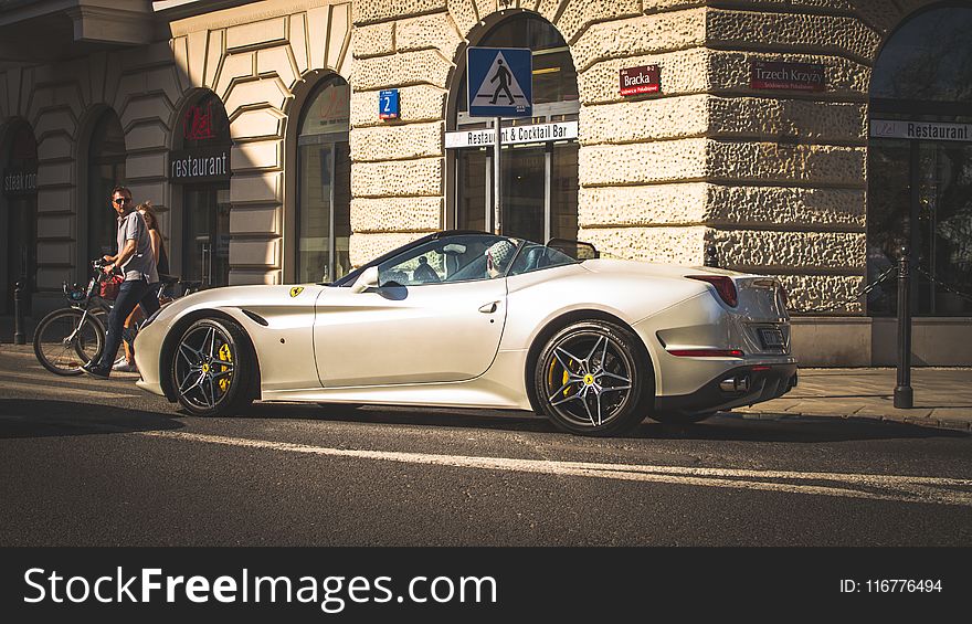 White Coupe Beside Grey Concrete Building