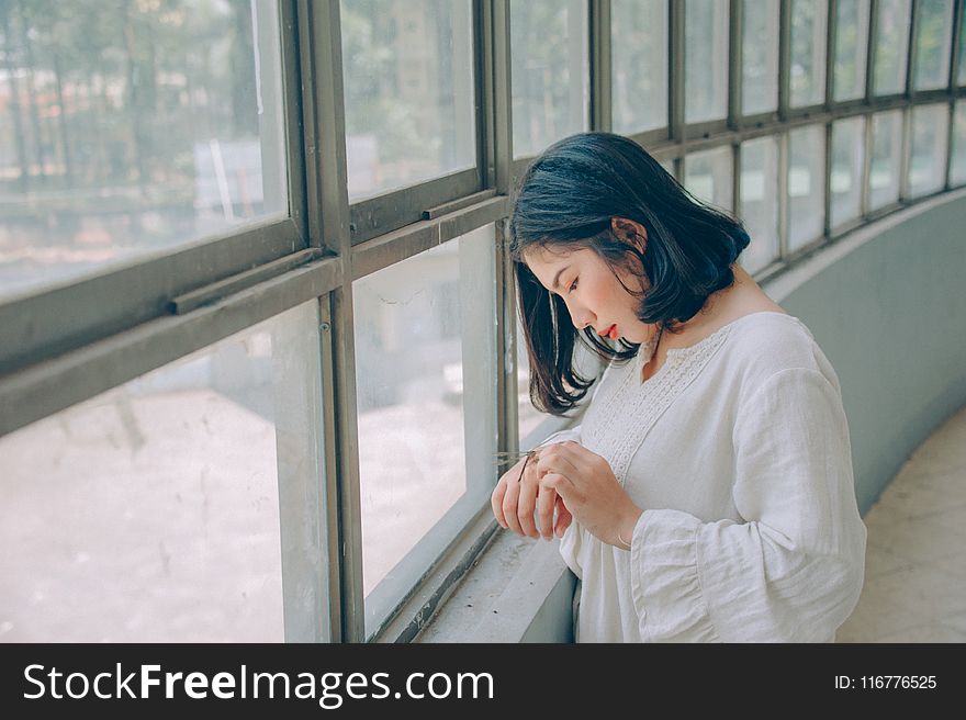 Woman in White Sweater in Front of Window