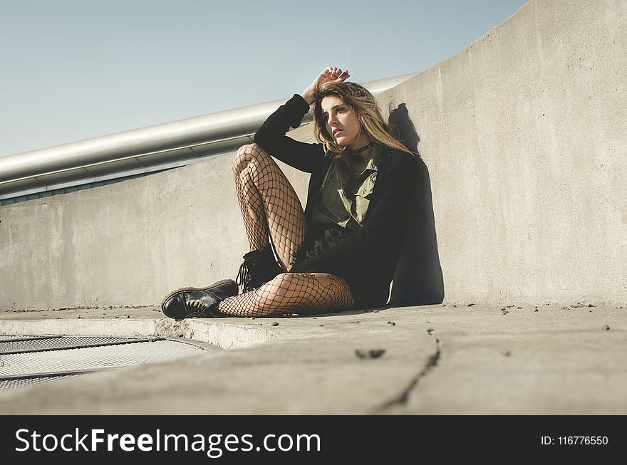 Photography of a Woman Leaning on a Wall