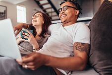 Cheerful Multi-ethnic Couple Relaxing At Home Royalty Free Stock Photography Cheerful Multi-ethnic Couple Relaxing At Home Royalty Free Stock Photography