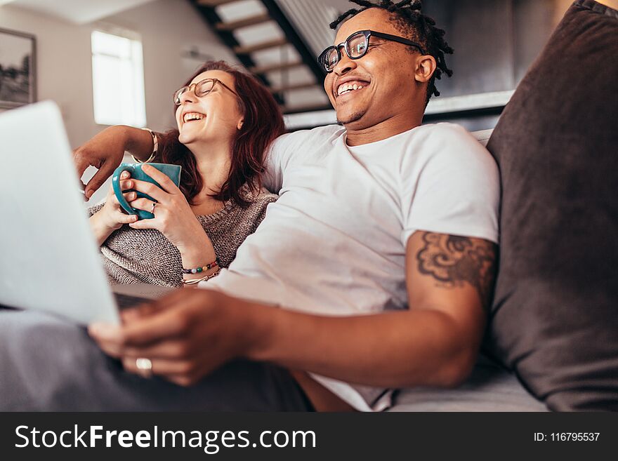 Cheerful multi-ethnic couple relaxing at home