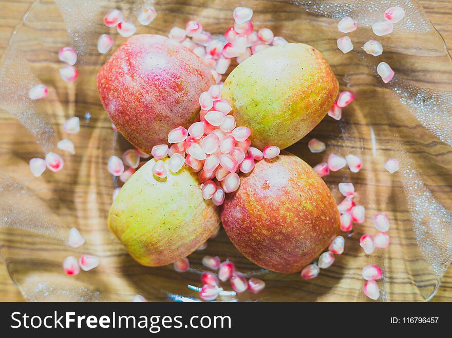 Fresh Apple Slices and pomegranate Seeds on a plate.