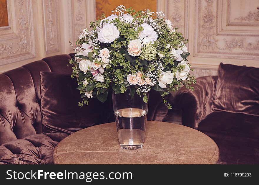 Bouquet of white roses on marble table in interior of the Baroque style