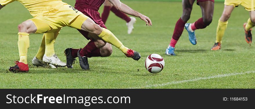 Soccer players running after the ball