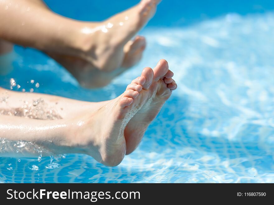 Legs in the pool splashing water