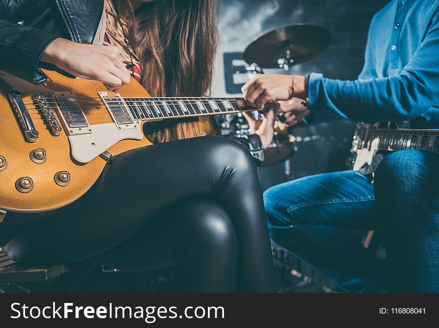 Guitar music teacher helping his student to play, closeup on the hands